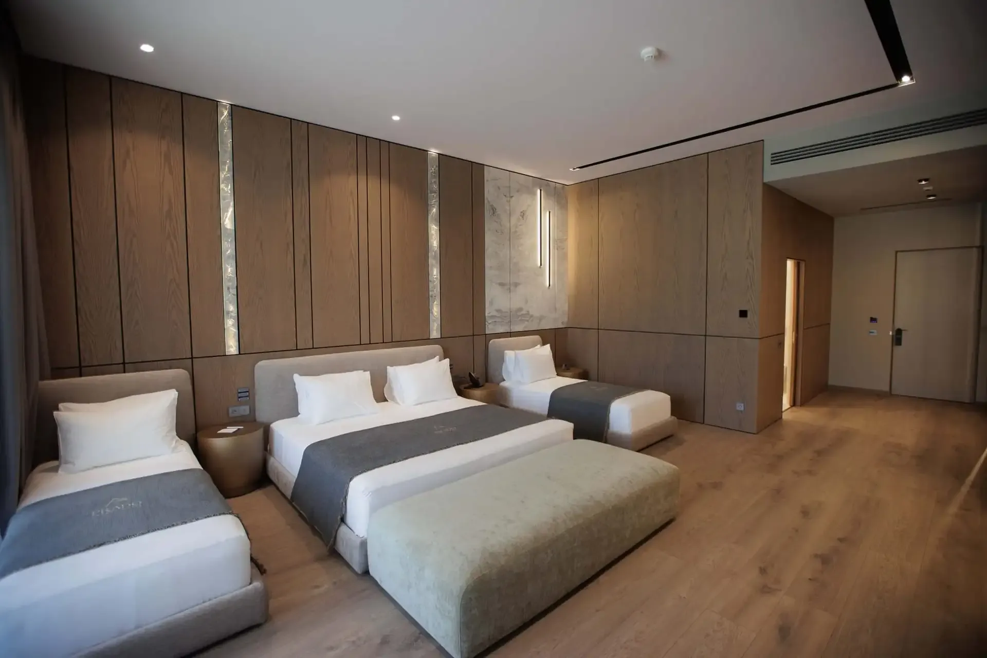 Two single beds and a large bed in a Family Suite at Prado