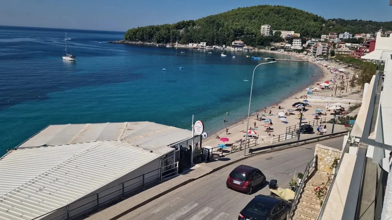 The curve of Spille beach and the seafront road seen from an upper balcony