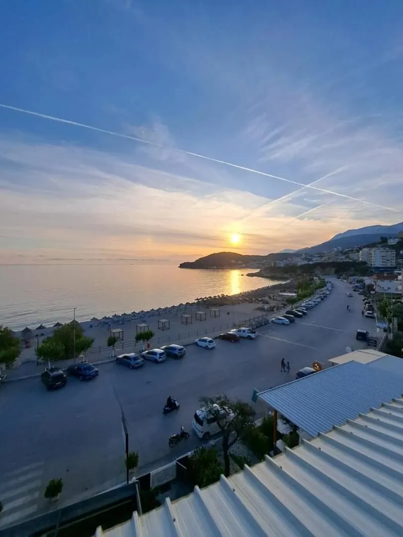 The coast road, parked cars and the bay at dusk seen from high on the hotel