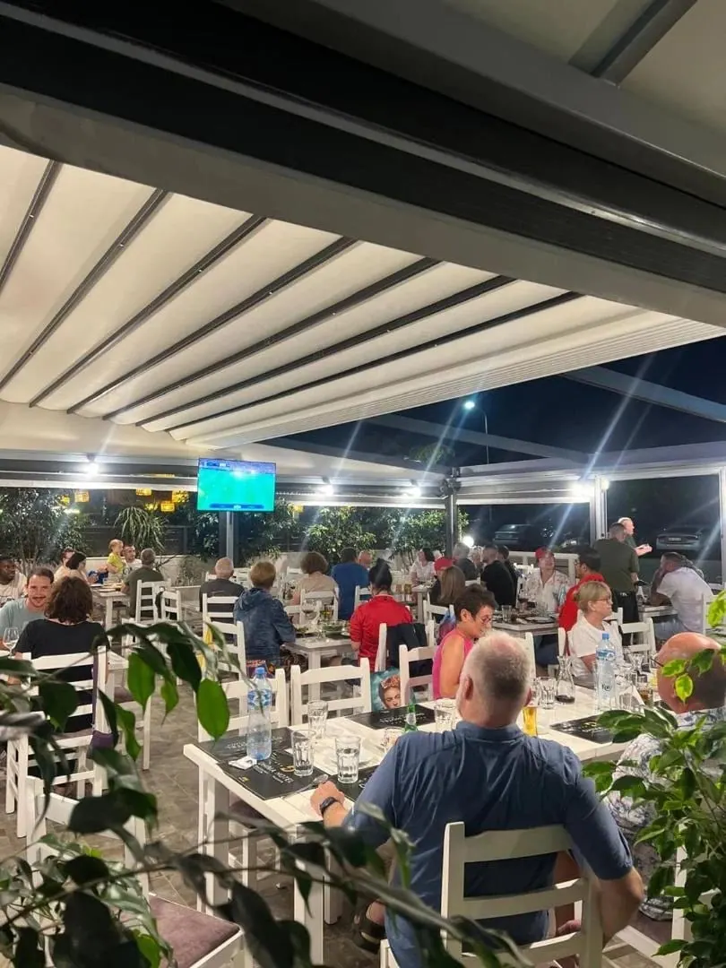 The restaurant terrace full of diners at night under bright ceiling lighting