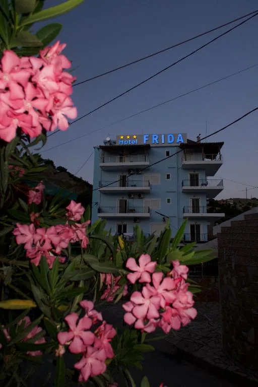 The Hotel Frida roof sign at dusk, above pink oleander