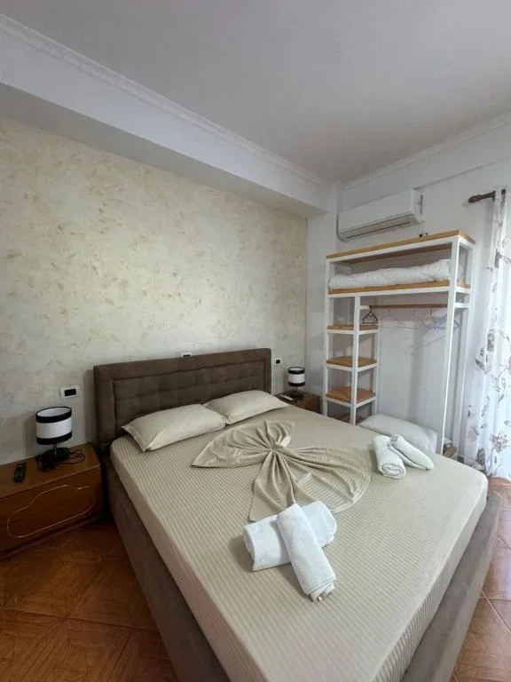A parquet room at Hotel Frida with an upholstered headboard and an open shelf unit