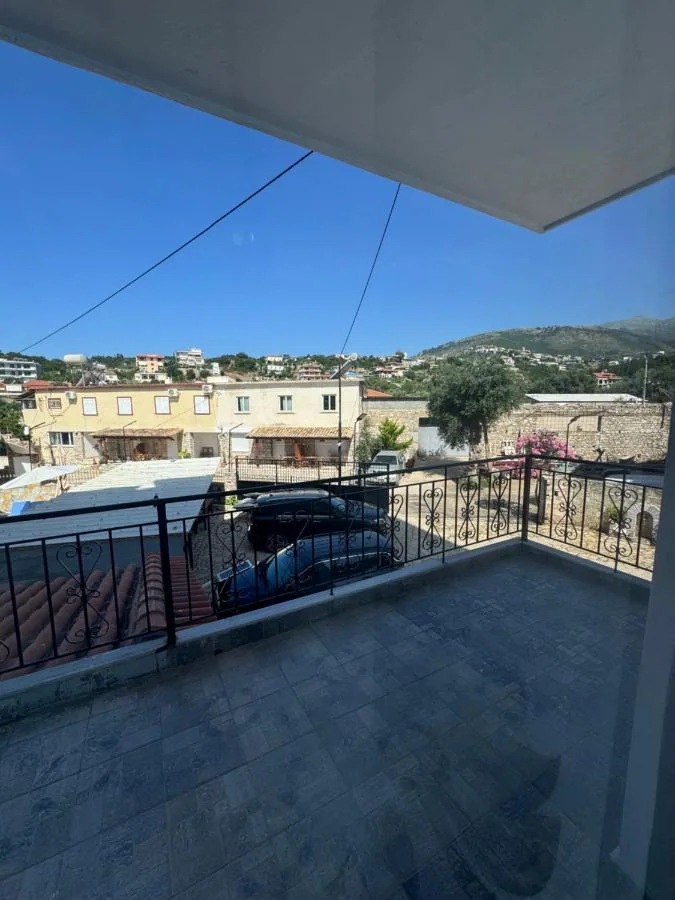 A balcony at Hotel Frida looking past a neighbouring roof to the hillside houses of Himarë