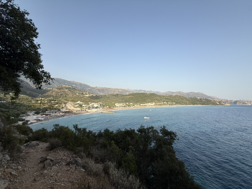 Livadh Beach coastline at dusk where BoHo Livadh sits among the bars and umbrellas, May 2026