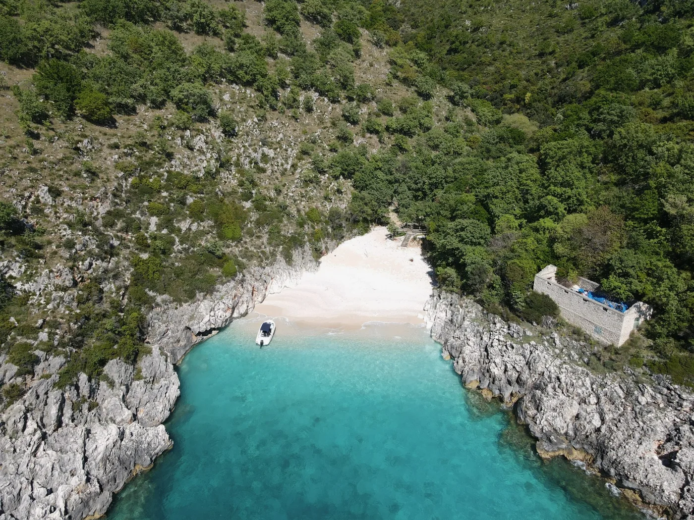 A small turquoise cove with a boat on the southern Albanian coast near Saranda