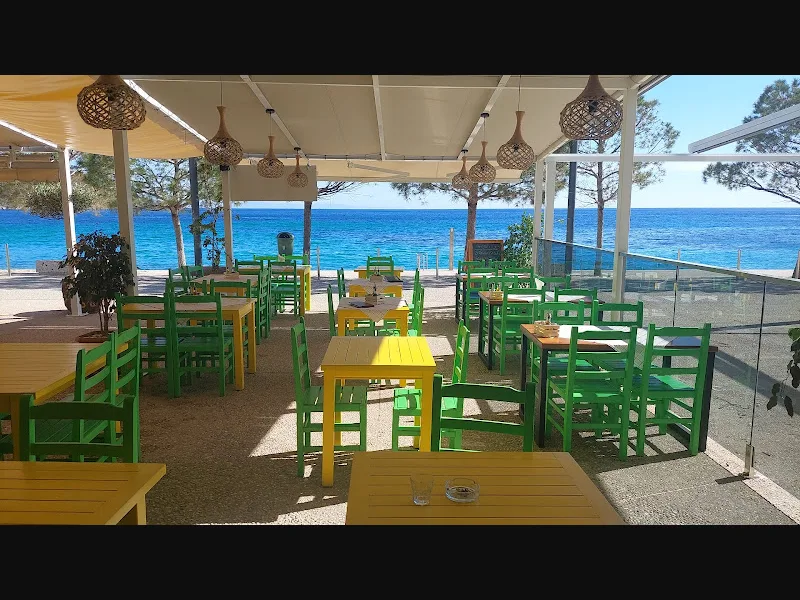 Sea-view terrace with green chairs at Hercules Restaurant in Himara