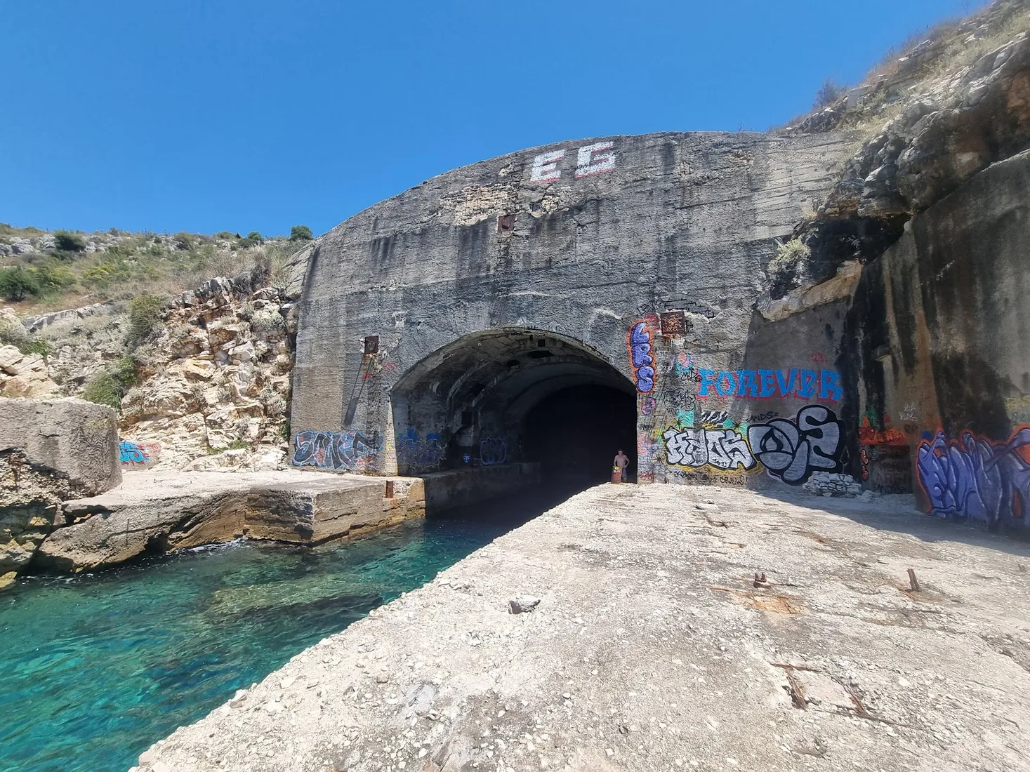 Submarine tunnel entrance carved into the cliff face at Porto Palermo