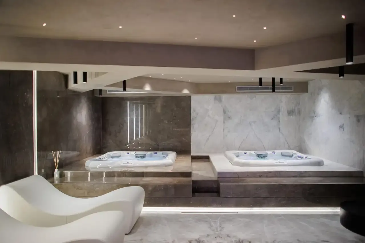 Moulded white loungers and a jacuzzi on its marble plinth in the spa at Prado