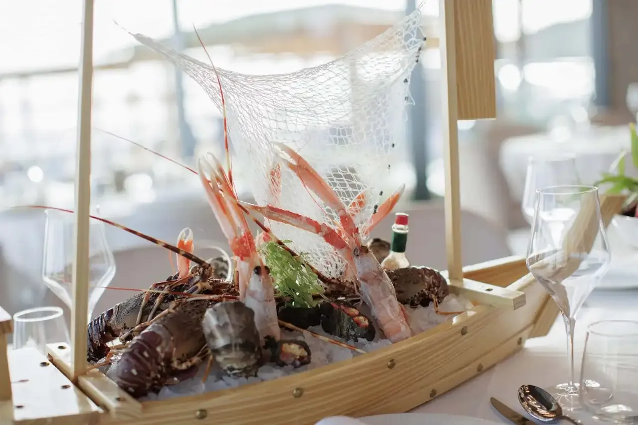A wooden boat of langoustines and shellfish on ice at the restaurant