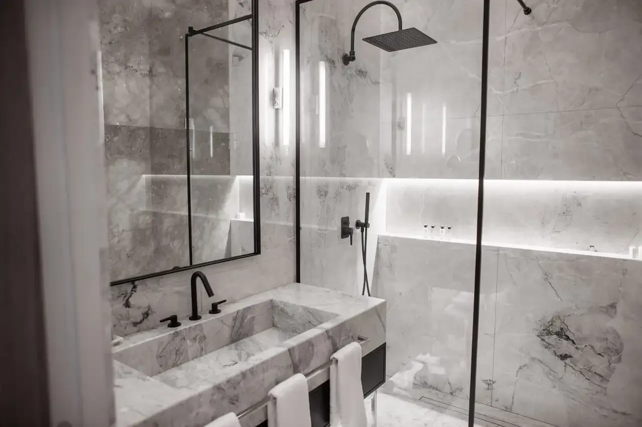 The grey marble bathroom of the Deluxe Suite with a walk-in shower