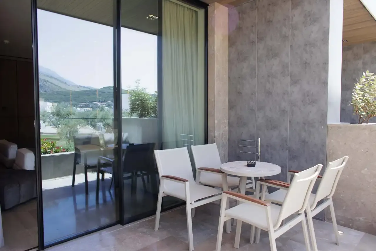 The balcony of a Family Standard Room with a table, chairs and planting along the rail