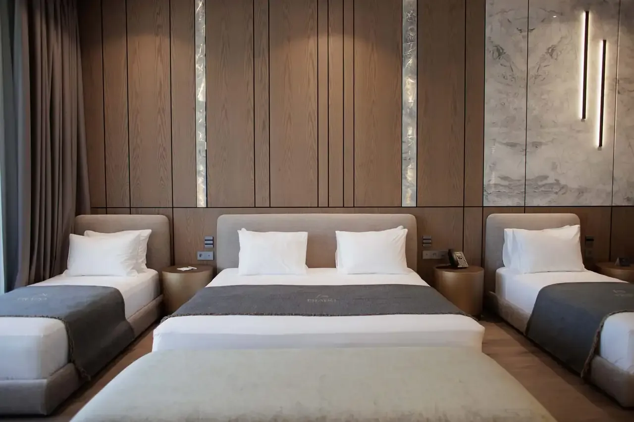 A Family Suite along its headboard wall: a large bed between two single beds