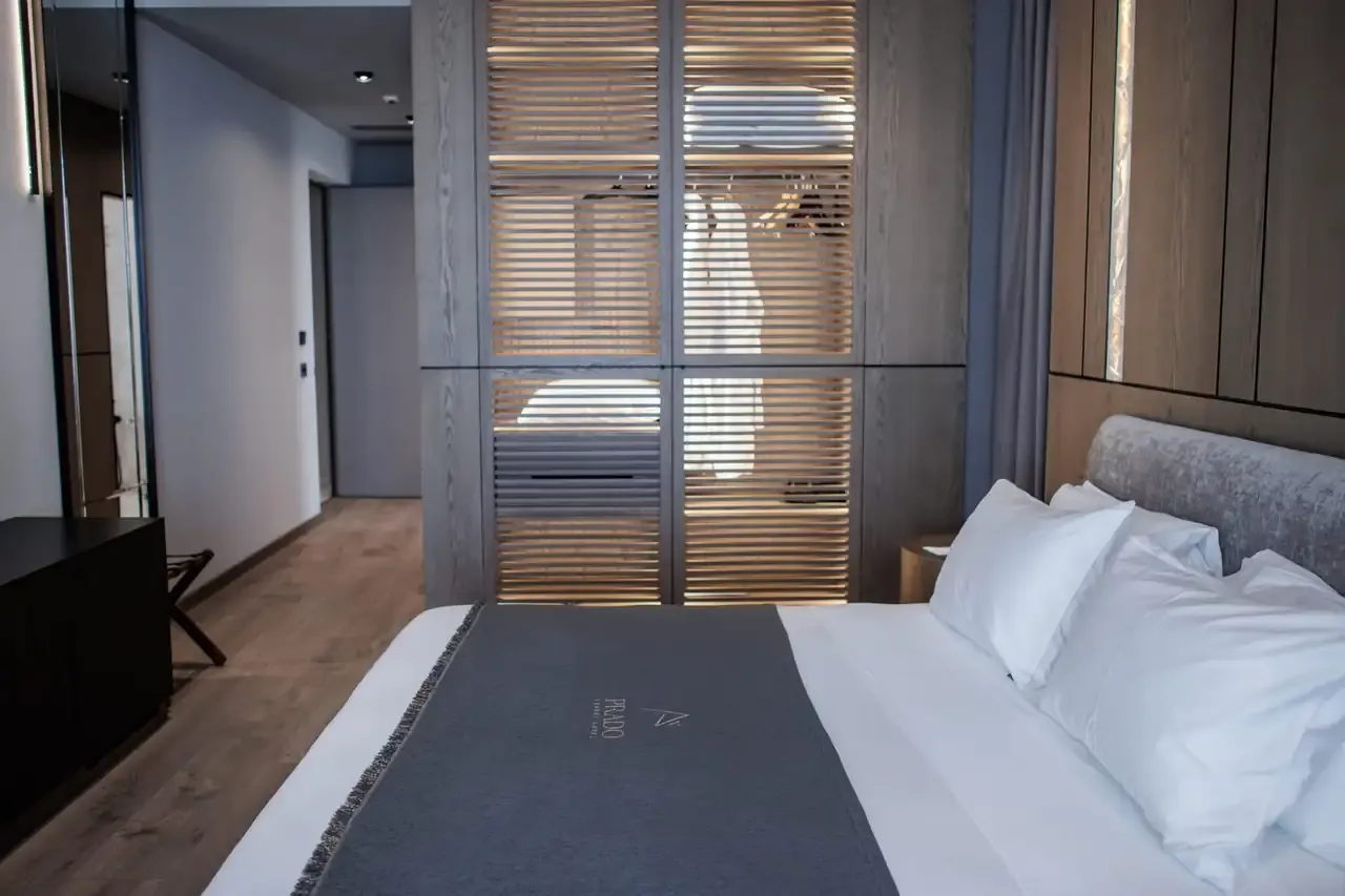 A Standard Room seen along its length, oak floor and a slatted timber wardrobe