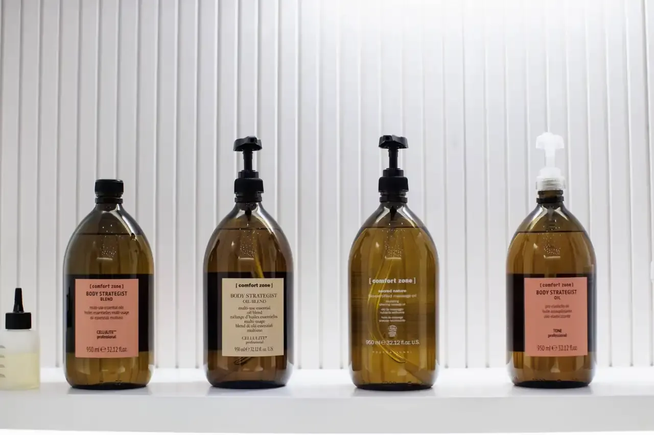 Amber glass bottles of treatment oils lined up on a white shelf