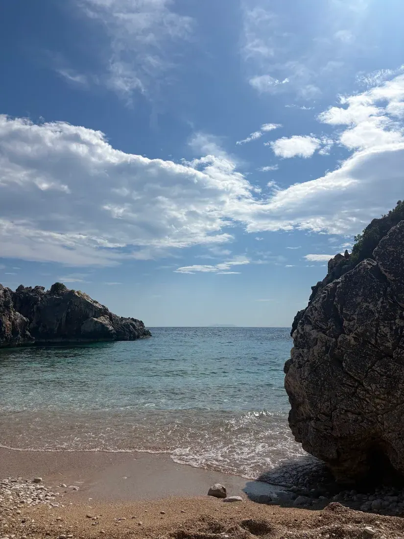 Akuarium Beach crystal-clear water meeting pebbles