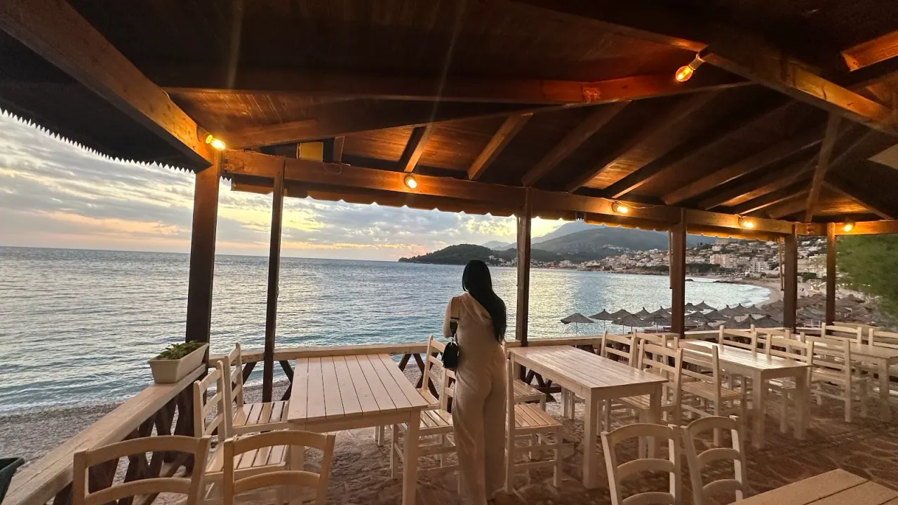 Wooden beachfront pergola with set tables at sunset at Lui Potam on Potam Beach in Himara