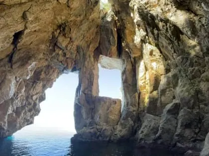 Tour boat anchored in crystal-clear waters along the Albanian Riviera coastline