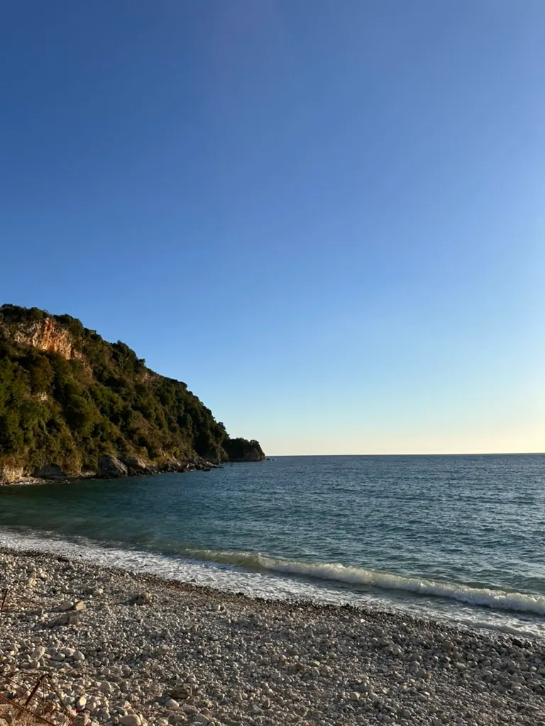 Paraglider soaring above the Albanian Riviera coastline from Llogara Pass