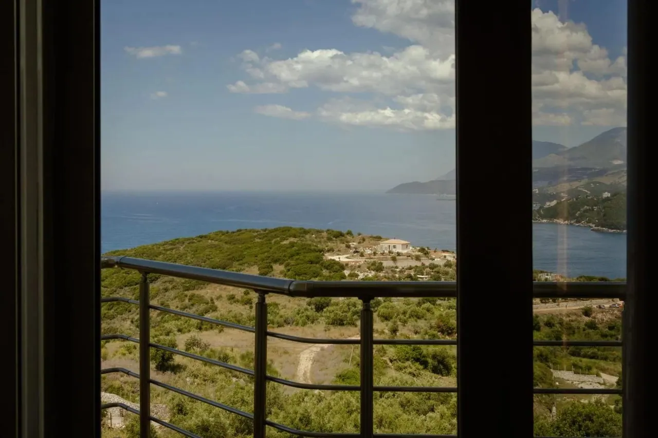 The bay and the coast road seen from a balcony rail