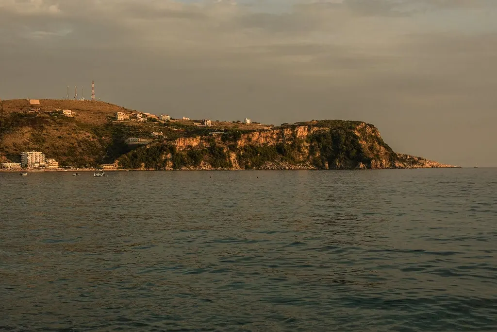 The Himarë headland at dusk, seen across the water with the old town on the ridge