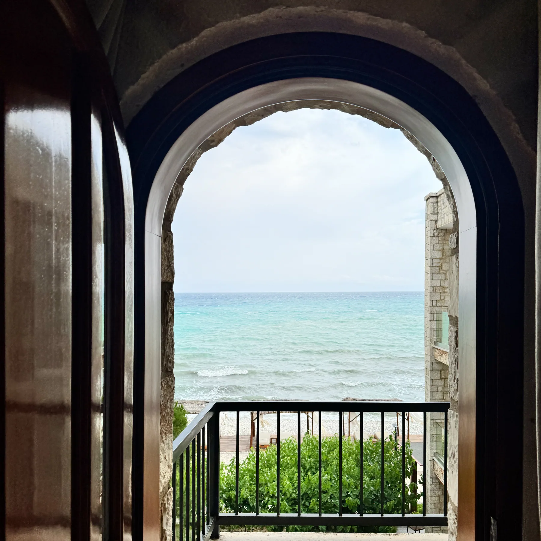 A pointed stone arch opening onto a balcony above the water