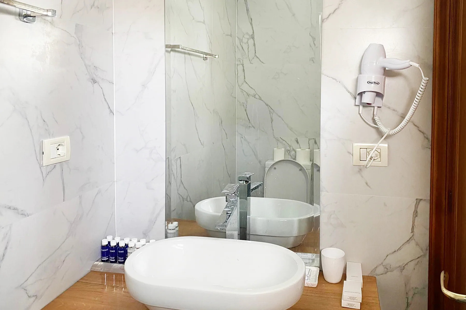 A white bath and basin in a marble bathroom