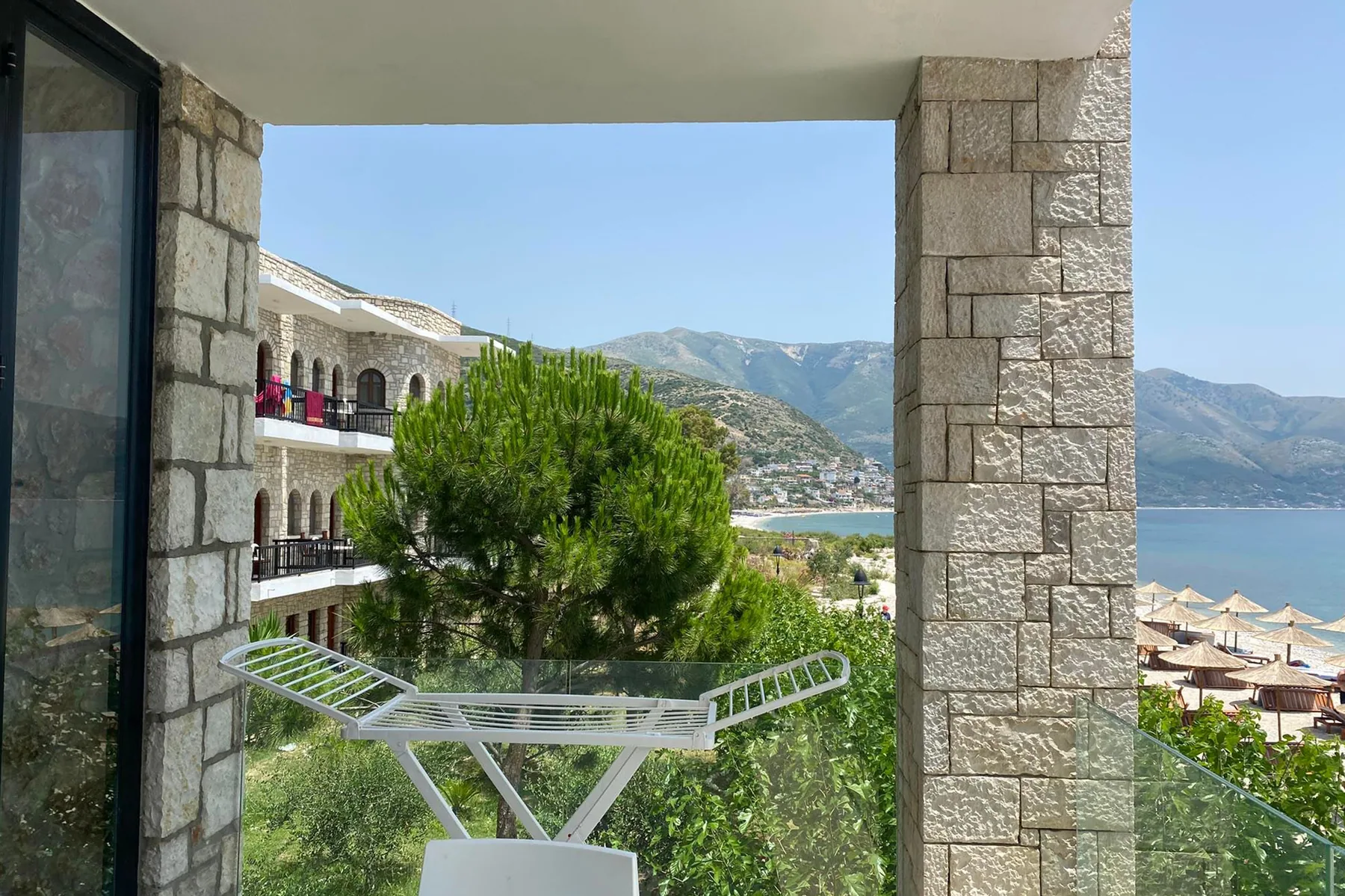 A balcony framed by heavy stone piers looking along the hotel front to the bay