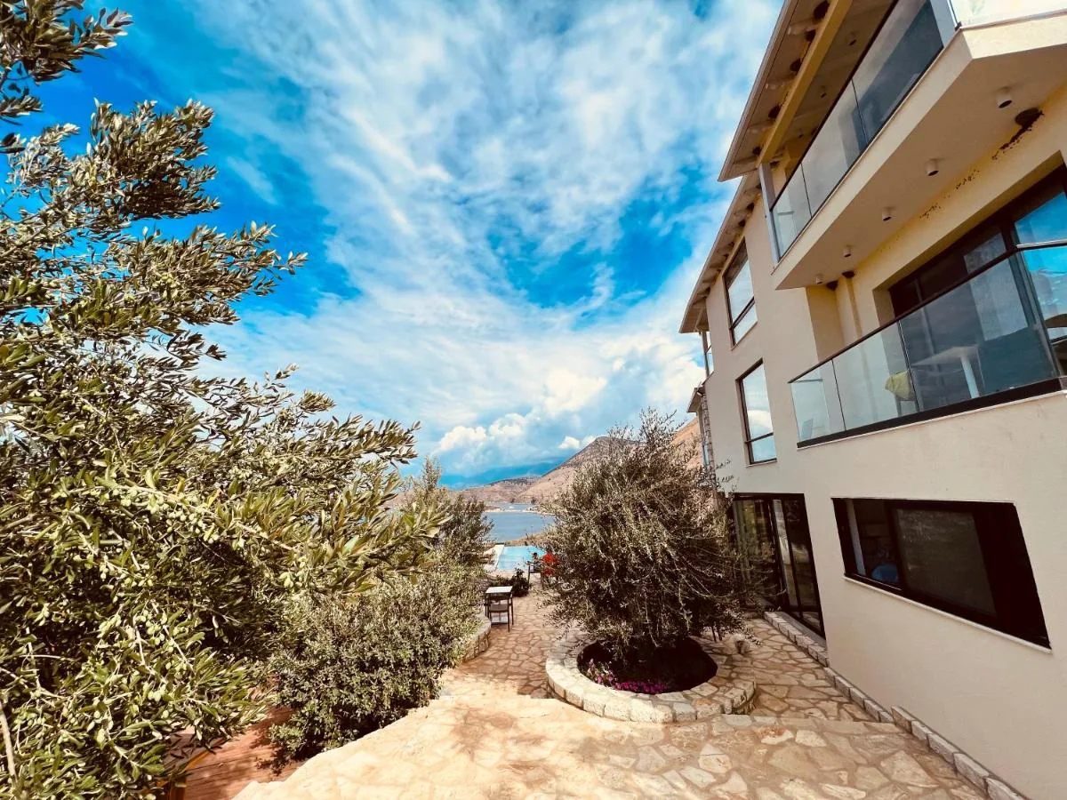 The stone path running down the side of the building towards the pool, olive trees on the left