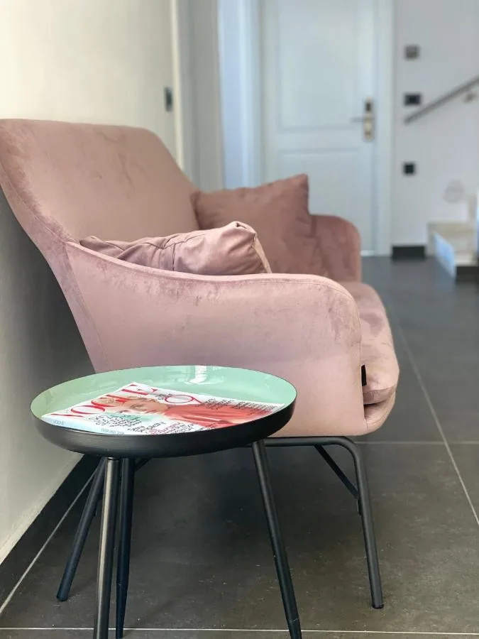 A dusty-pink armchair and a small round side table in the shared lounge