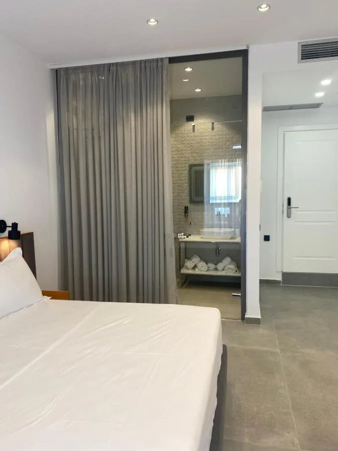 A bed with the bathroom visible behind a floor-length curtain