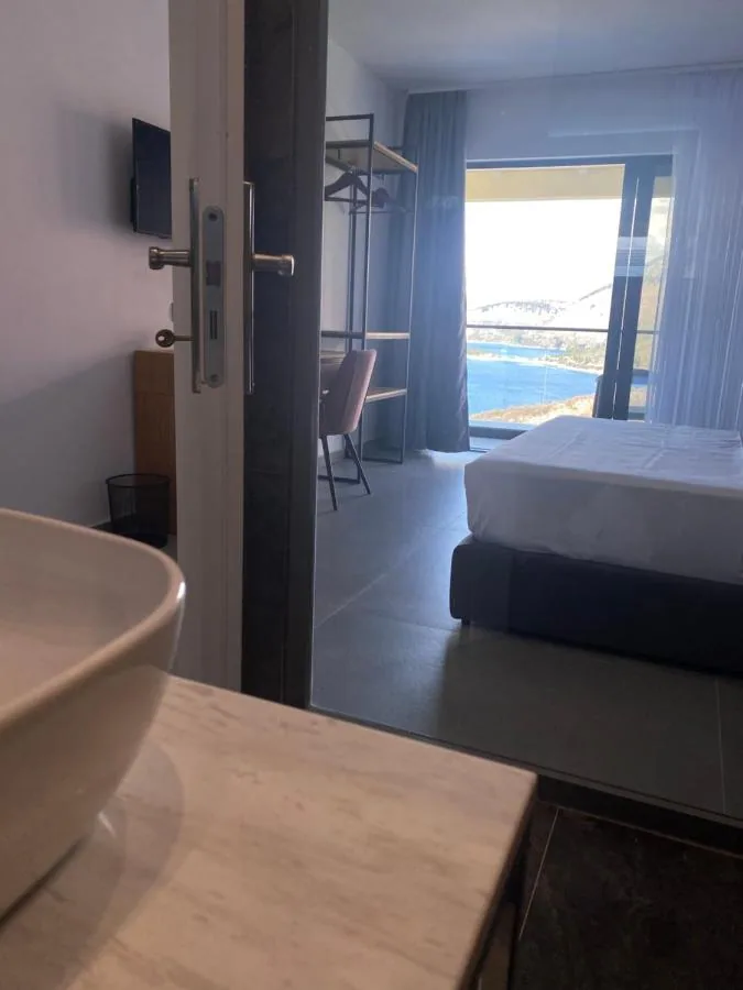 Looking from a bathroom doorway through a room to the balcony and the water beyond