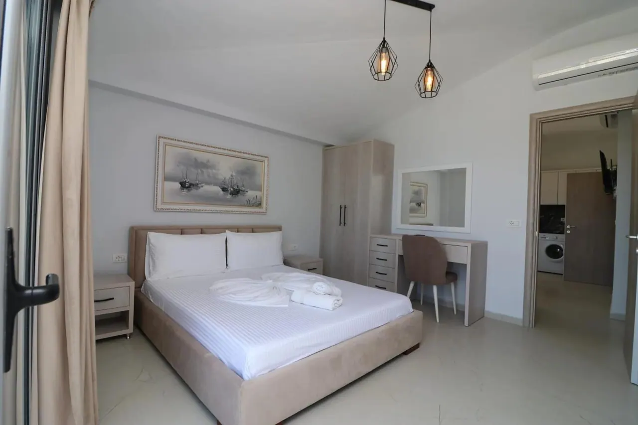Apartment bedroom with a wide bed and a door onto the balcony