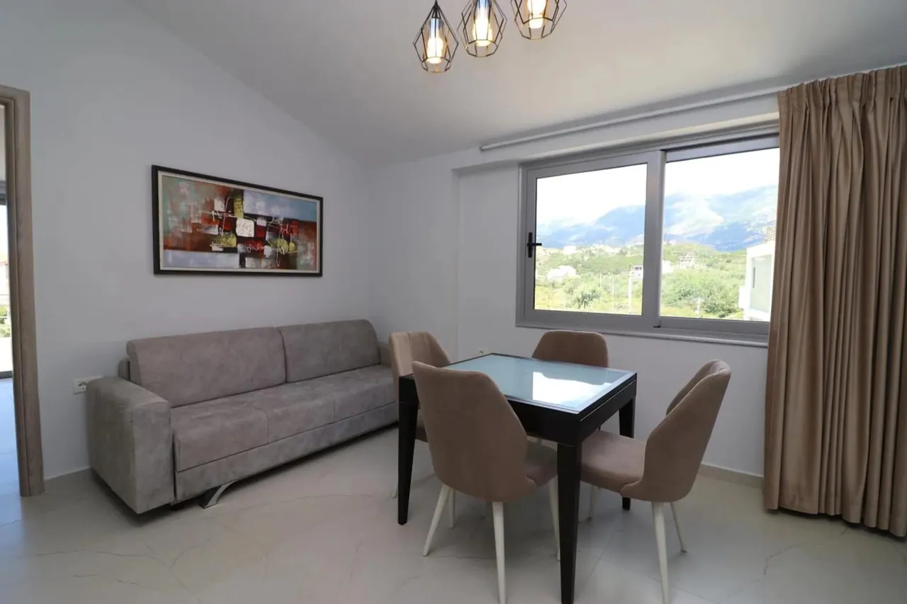 Apartment living room with a sofa, dining table and mountain view