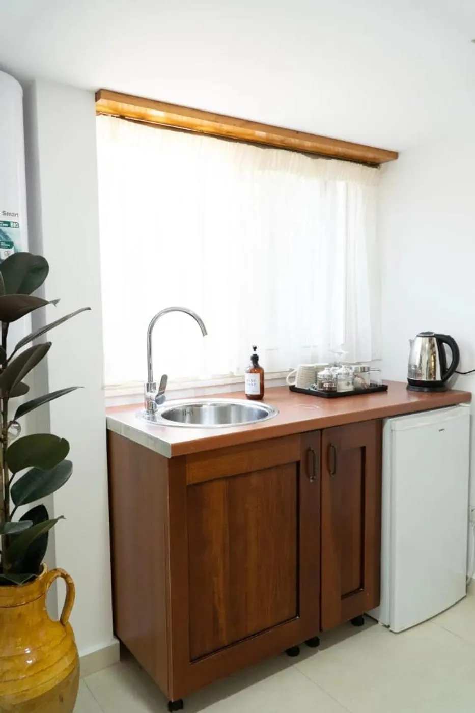 Walnut kitchenette with a glazed ceramic jug and a potted plant