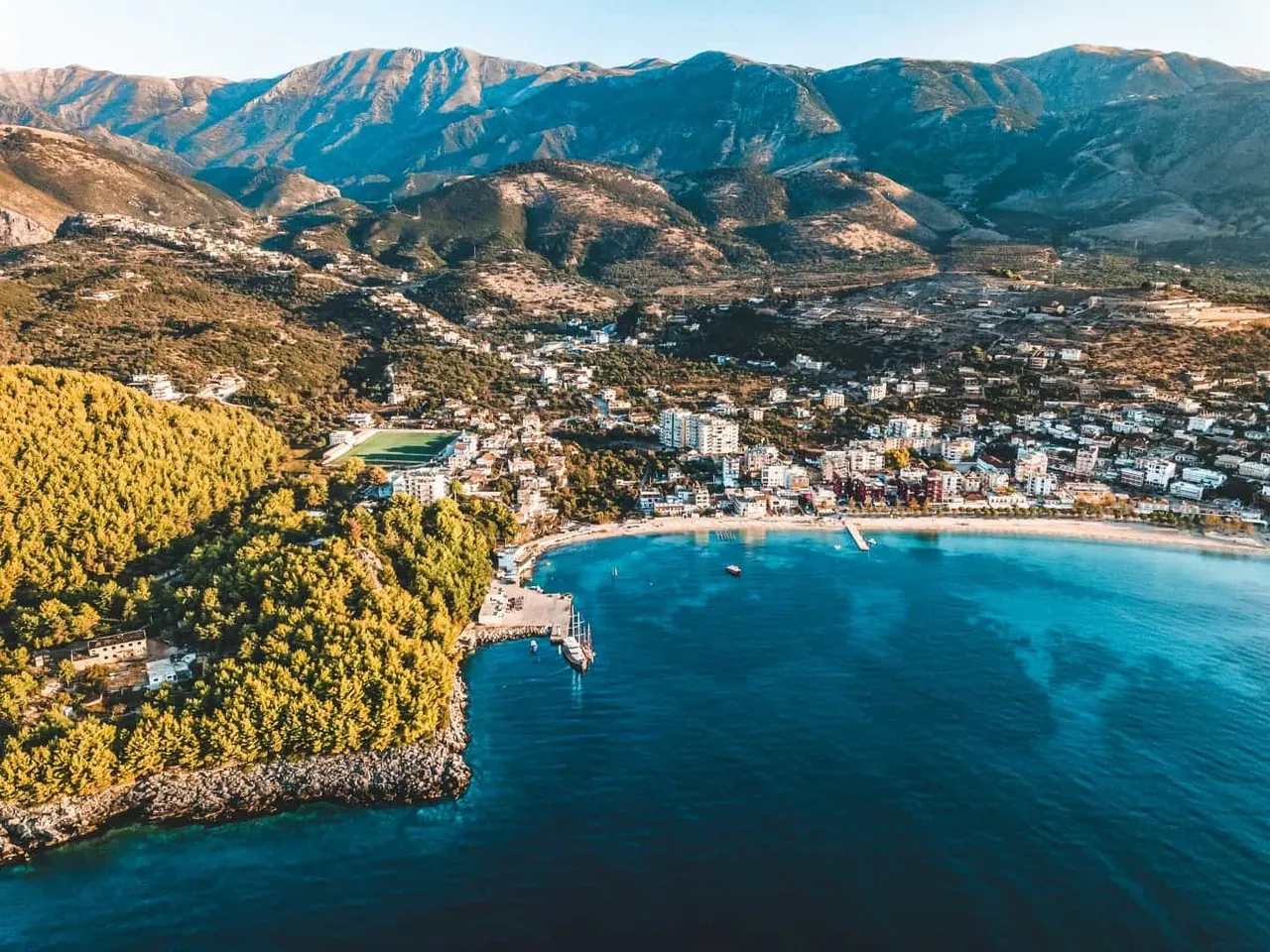 Aerial view of Himarë town and its turquoise bay from the water