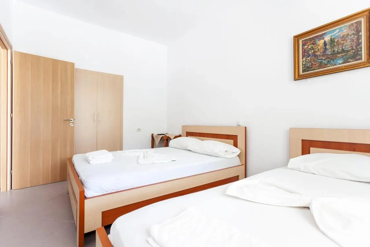 Bedroom with two wooden bedsteads and a wardrobe