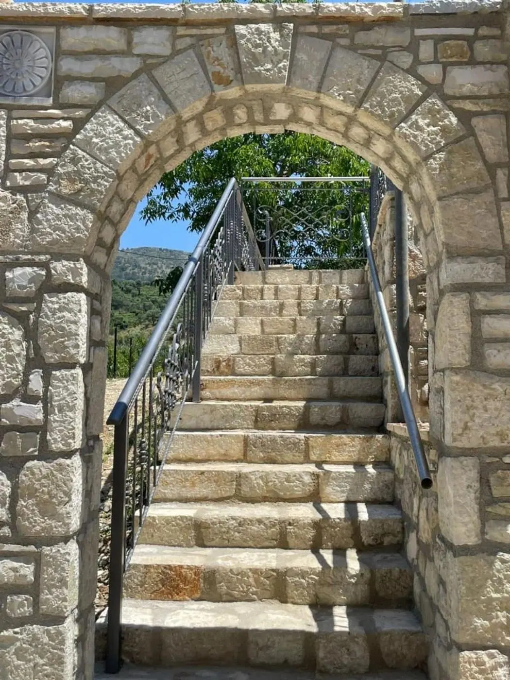 A limestone arch over the steps that lead up into the garden