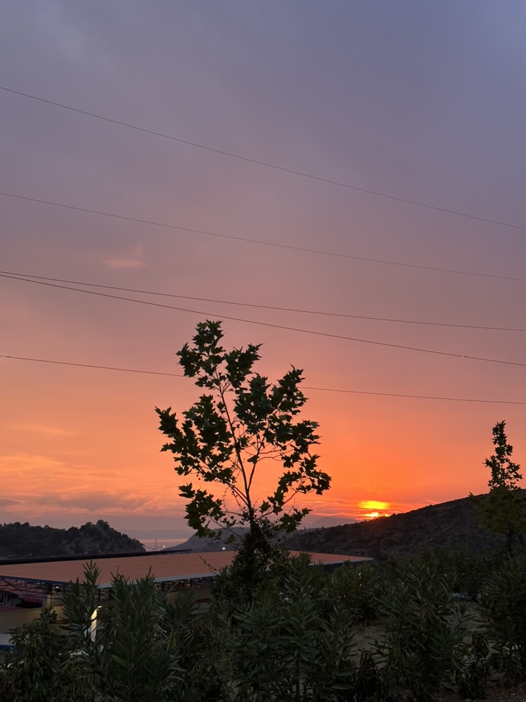 Buneci Beach bay with calm water and a small pier at sunset