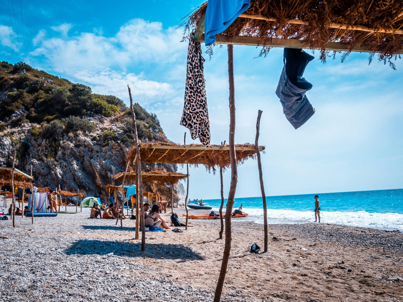 Gjipe Beach with pebble shoreline, sea caves, and turquoise Ionian water