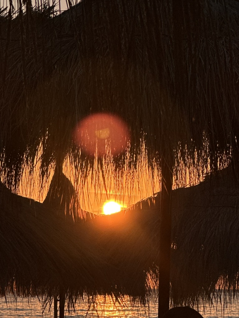 Sunset silhouette over beach umbrellas in Himara, ideal photography subject