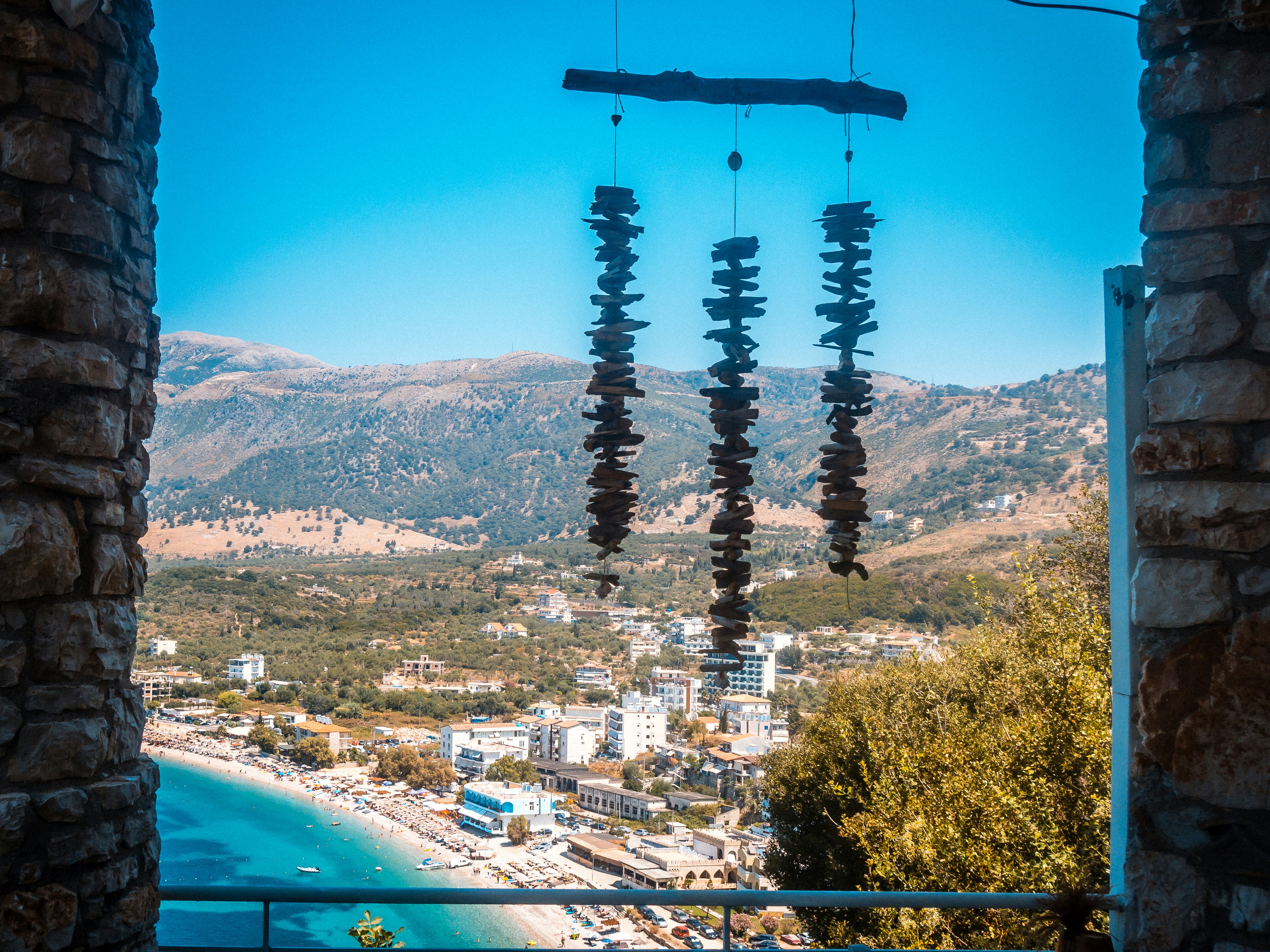 Himara Spile beach area with the old town arch and coastal promenade