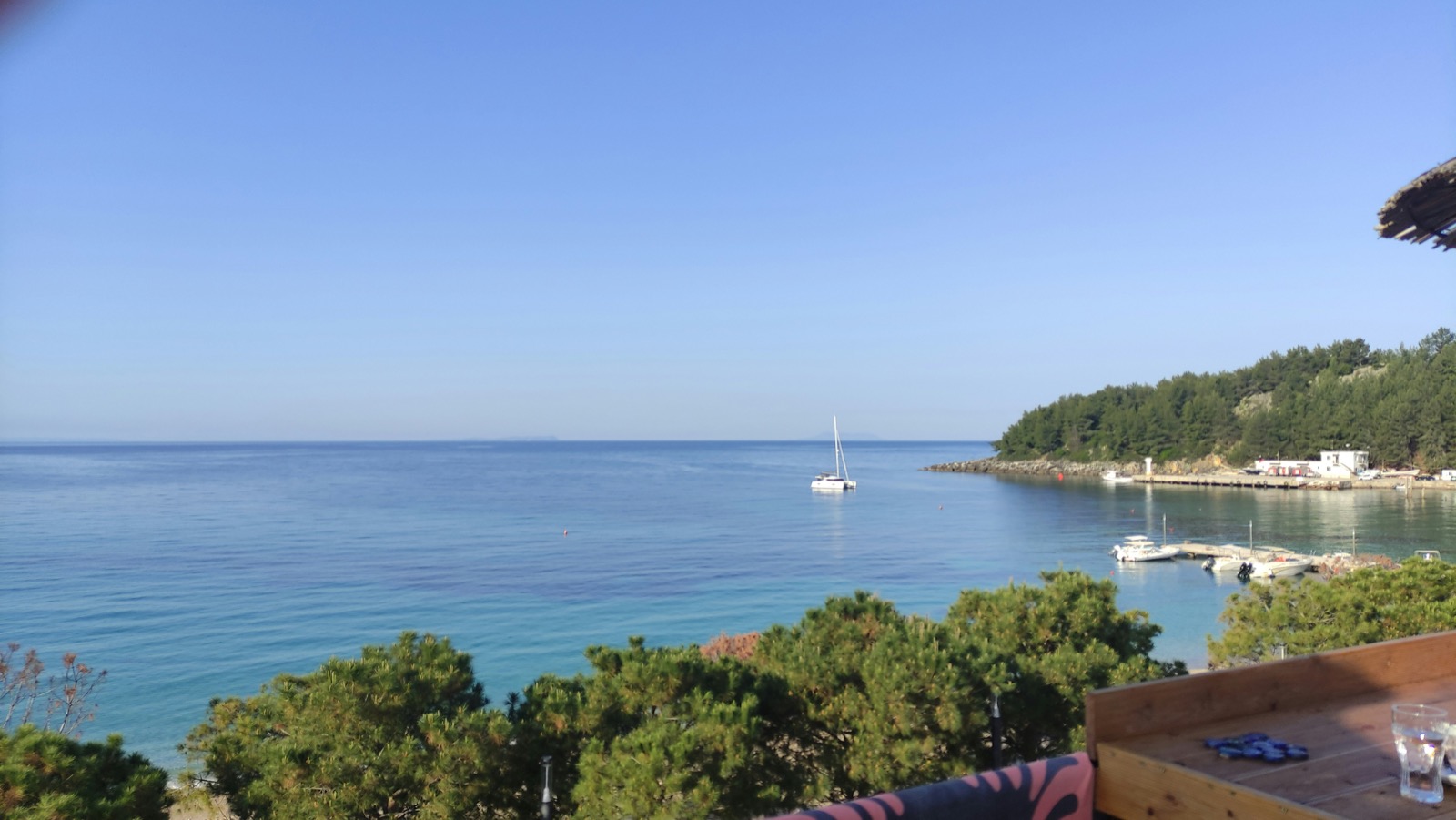 View from a seaside terrace in Himara with a sailboat on the Ionian Sea