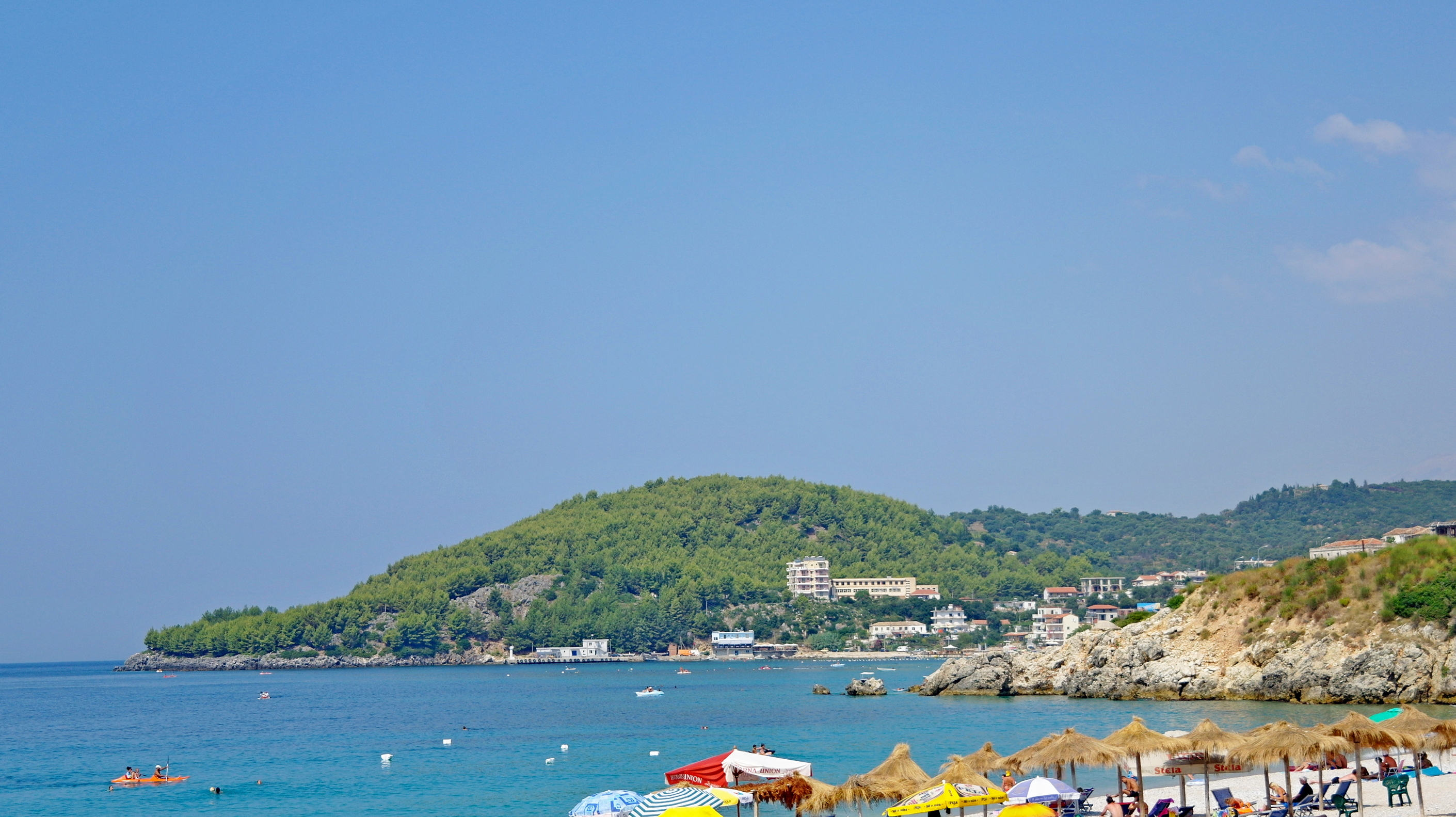 Beach sunbeds and straw umbrellas lined along Jale Beach on the Albanian Riviera