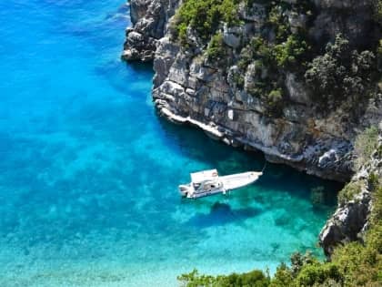 Boat approaching Pirate's Cave along the Albanian Riviera coastline