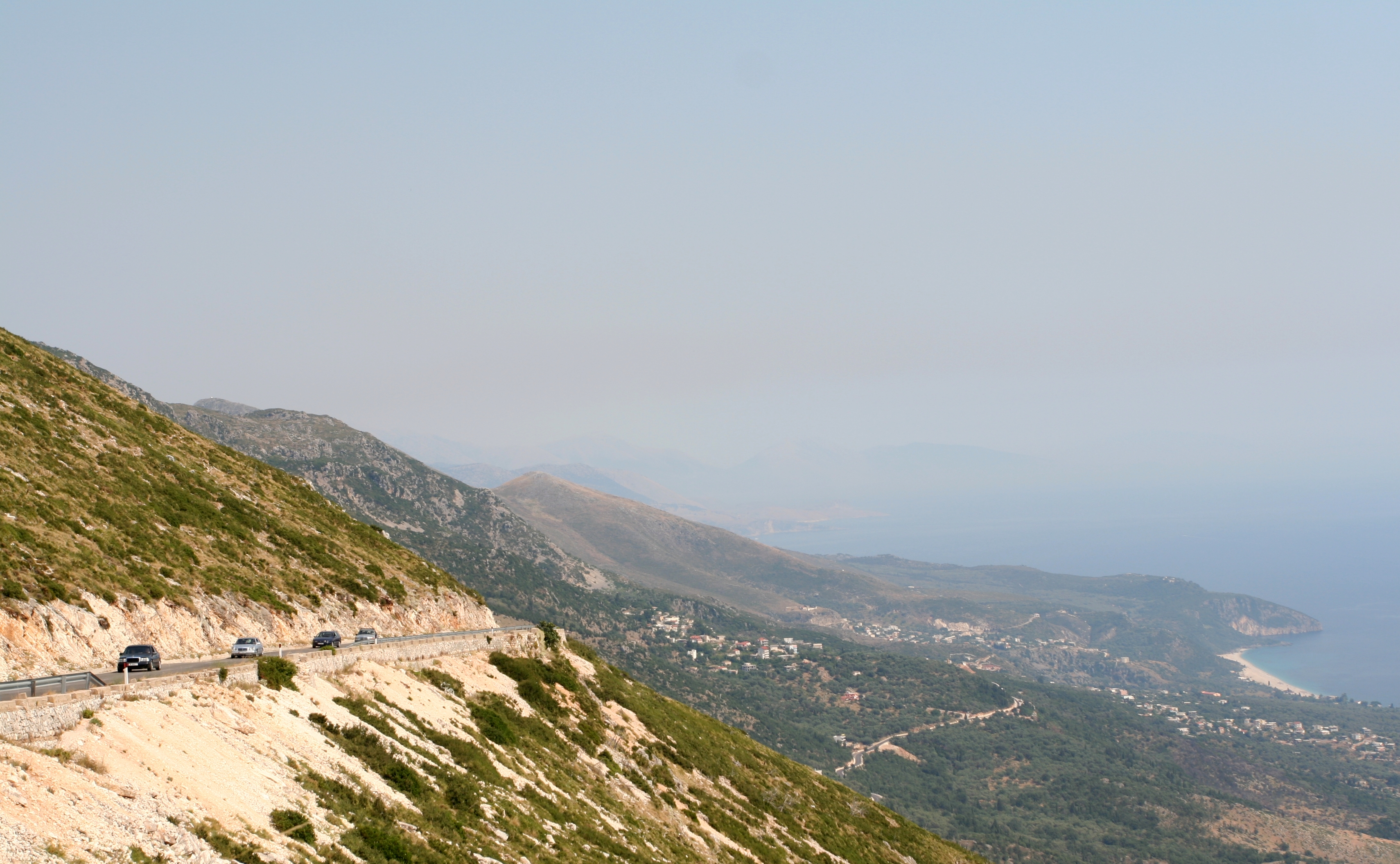 Winding coastal road along the Albanian Riviera with views of the Ionian Sea