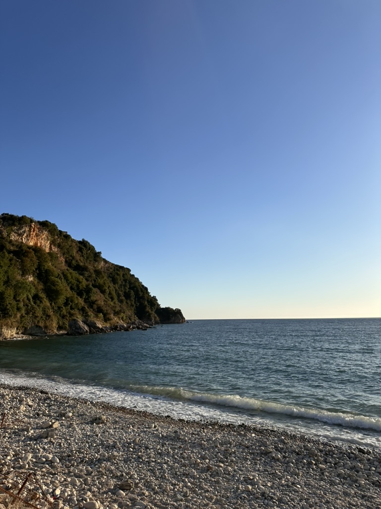 Paraglider soaring above the Albanian Riviera coastline from Llogara Pass