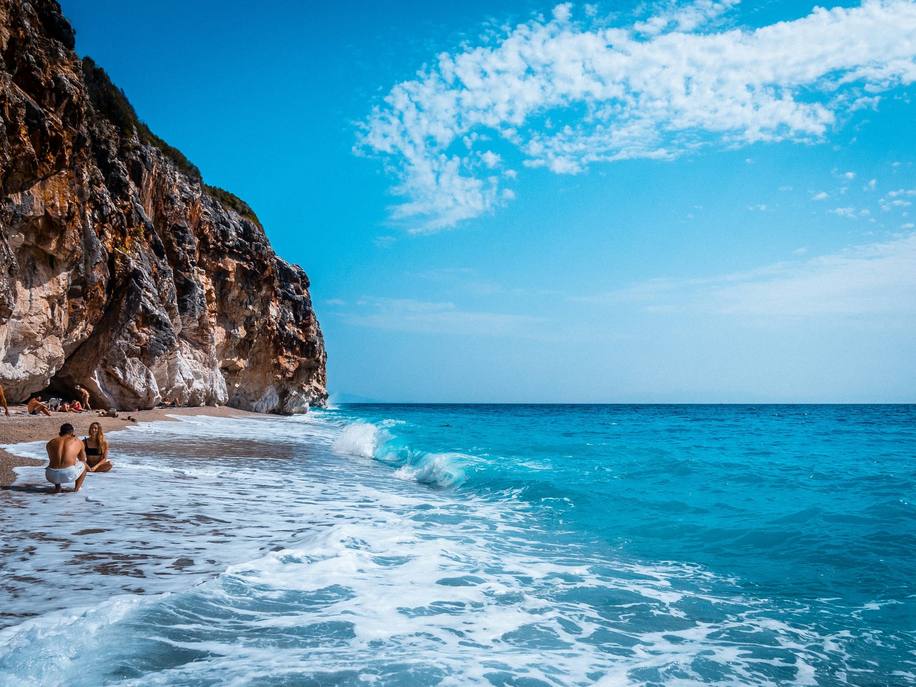 White limestone cliff falling into turquoise water at Gjipe beach on the Albanian Riviera