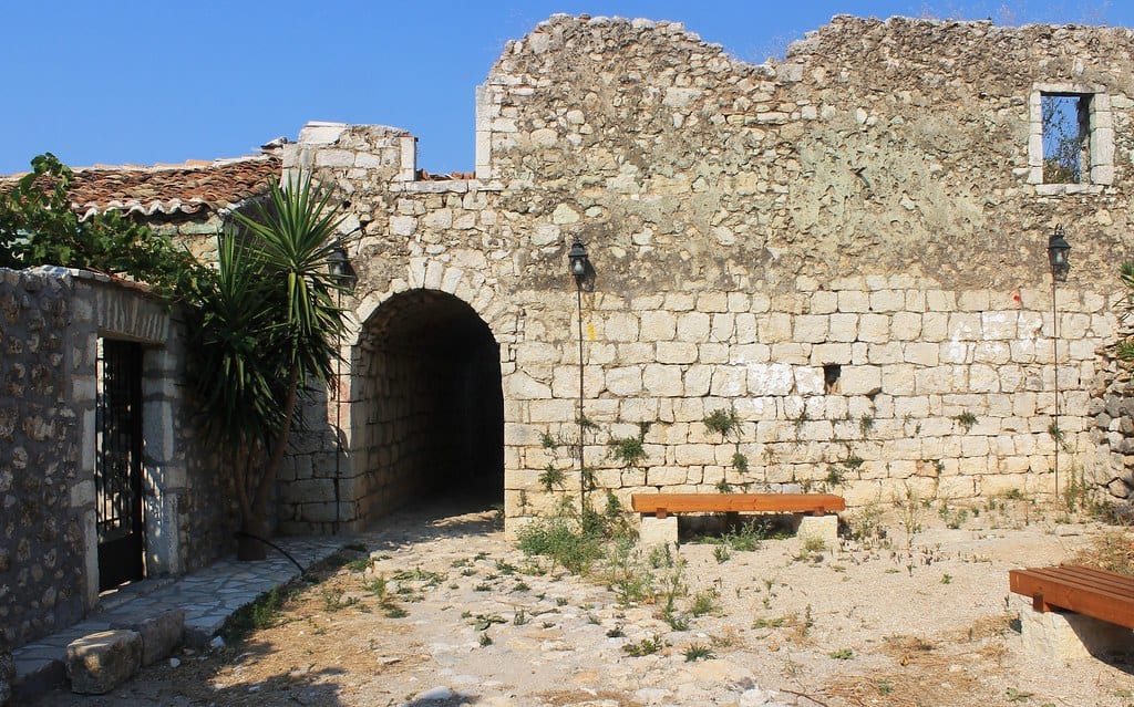 A stone arch and dry-laid walls inside the ruined old village of Himarë Castle