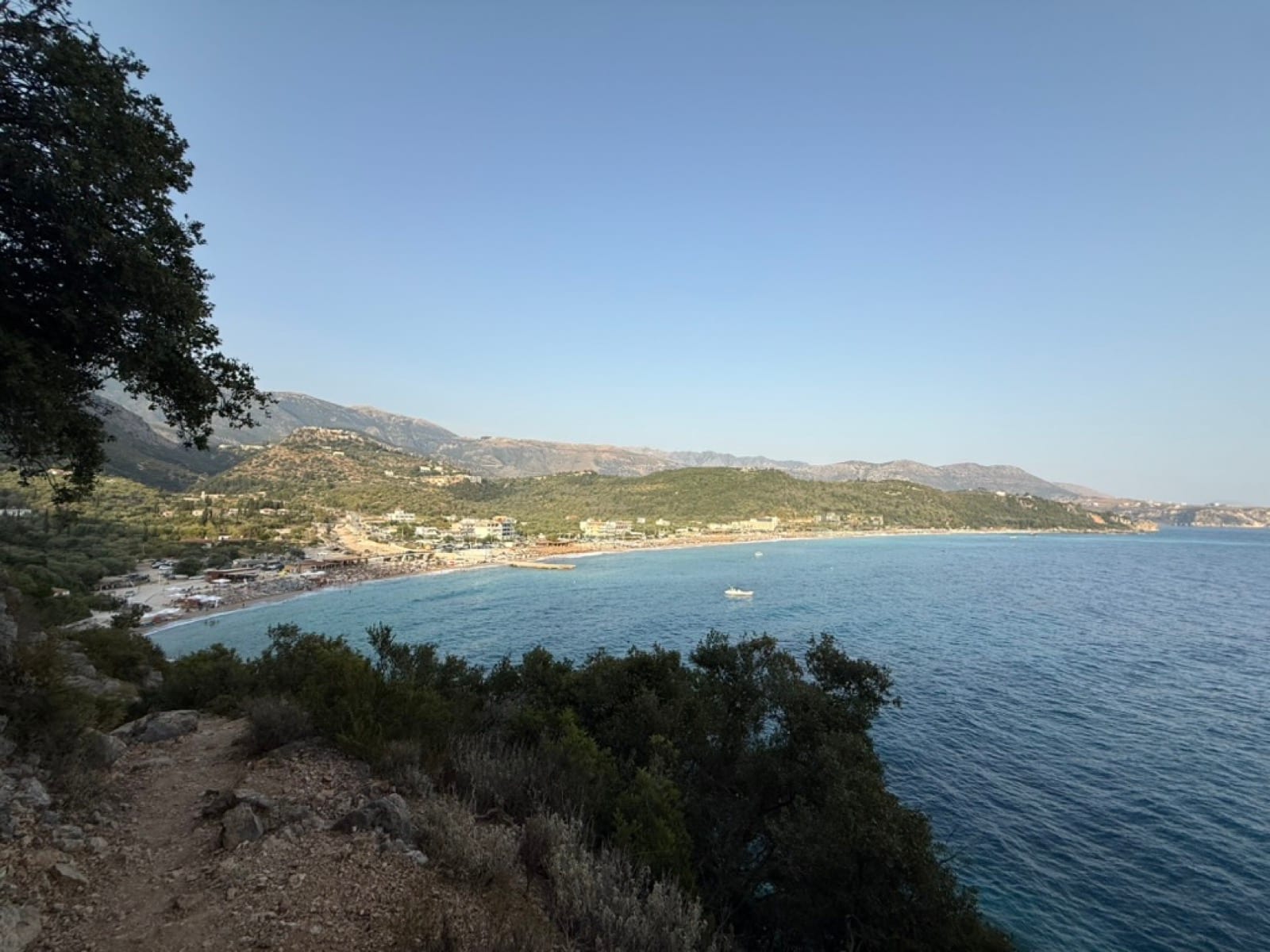 Livadhi Beach and its bay seen from the hillside above, the Ionian Sea calm below the coastal mountains