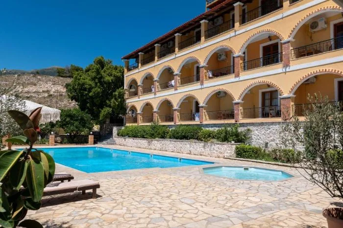 The arcaded elevation above the flagstone deck with the long pool in front and the small round children's pool beside it